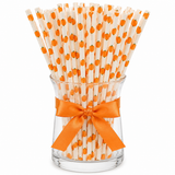 Glass filled with pumpkin print paper drinking straws tied with an orange satin ribbon, perfect for Halloween, Thanksgiving, and fall party decorations.