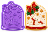 A holiday-themed cookie cutter or decorative shown in two views: a purple empty mold on the left and a filled example on the right featuring polar bears, a red bow, holly, snowflakes, and gold stars on a white snowy arch background.