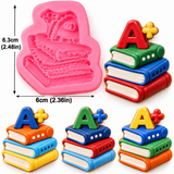 Colorful pastel stacked schoolbooks decoration featuring three books with detailed pages and a raised A+ symbol, displayed in pink, lavender, blue, green, and yellow combinations for school-themed cakes and desserts.