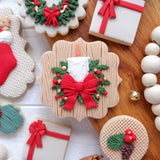 Christmas candle and bow silicone mold shown beside a finished holiday decoration with evergreen and berries.