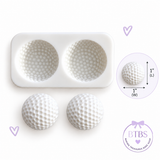 Golf ball 2-cavity silicone mold with finished golf ball examples measuring approximately 1 inch wide by 1 inch long.