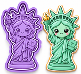Kawaii Statue of Liberty cookie cutter and embosser stamp set in royal orchid lavender beside a decorated mint-green Statue of Liberty sugar cookie holding a torch and tablet.