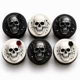 : Gothic Halloween cupcakes featuring black, white and silver skull toppers accented with small red and black roses.
